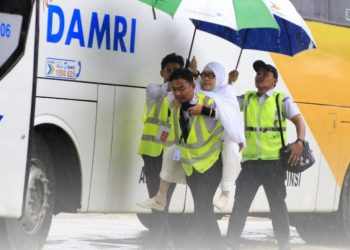 Petugas Debarkasi Haji Padang menggendong jemaah yang sakit