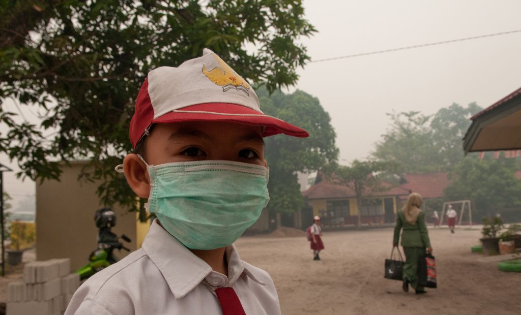 Ilustrasi pelajar memakai masker akibat kabut asap
